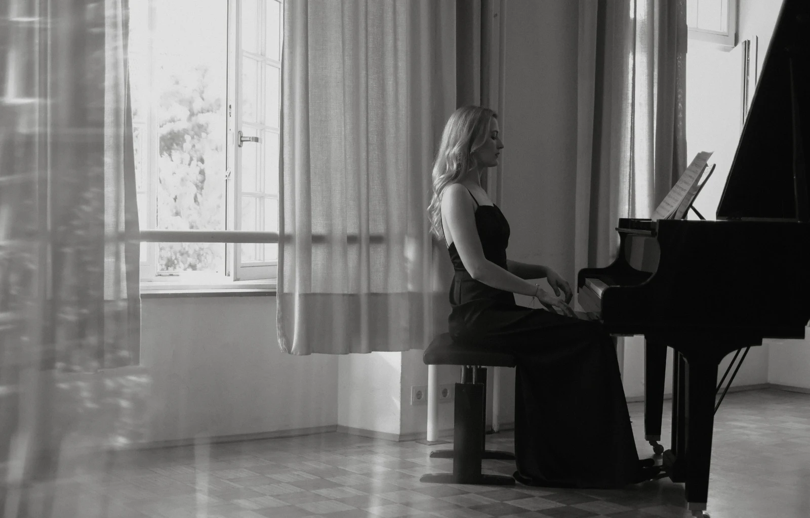 Pianist at a grand piano in a bright room