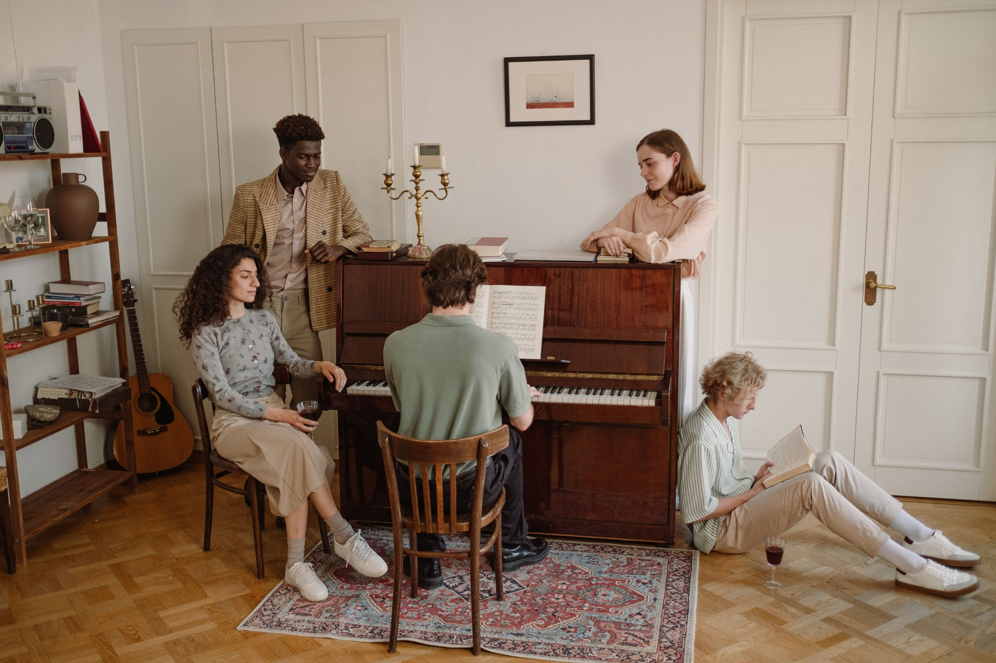 Friends gathered around an upright piano